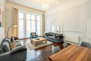 a living room with a couch and a table at SouthKen Palace Suites in London