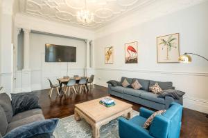 a living room with a couch and a table at SouthKen Palace Suites in London