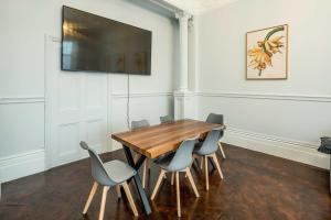 a dining room with a wooden table and chairs at SouthKen Palace Suites in London +13 photos