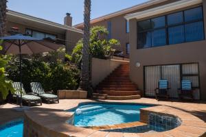 a swimming pool in front of a house at Grandview Guesthouse in Cape Town