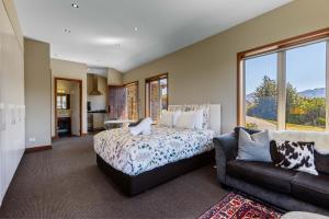 una camera da letto con un letto e un divano di Studio Nestled in Ridgecrest a Wanaka