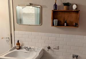 a bathroom with a white sink and a mirror at La Ca' nel Borgo in Moltrasio