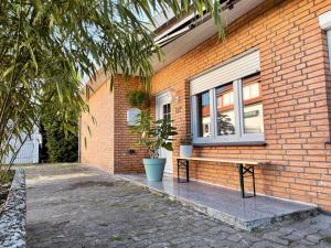 a bench in front of a brick building with a window at Senne Bungalow in Augustdorf
