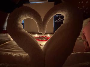 a large white heart on top of a bed at Casa da Avó Miquinhas in Paços de Ferreira