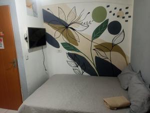 a bedroom with a bed with a painting on the wall at Refúgio de Piratininga 105 in Niterói