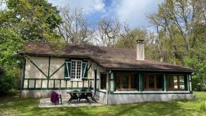 una casa vieja con una mesa de picnic delante de ella en Gite Noisy, en Noisy-sur-École
