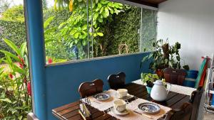 a table with cups and plates on it on a patio at Casa Azul in Penha