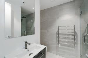 une salle de bain blanche avec lavabo et douche dans l'établissement Stylish & Modern Wanaka Townhouse - Your Dream Holiday Awaits, à Wanaka 8 autres photos