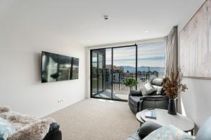 un salon avec deux chaises et une grande fenêtre dans l'établissement Stylish & Modern Wanaka Townhouse - Your Dream Holiday Awaits, à Wanaka