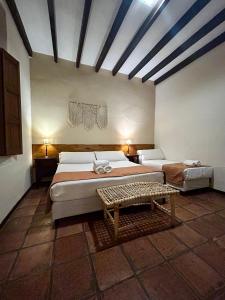 a bedroom with two beds and a table in it at Hotel Plaza Cafayate in Cafayate