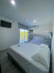 Un dormitorio con una gran cama blanca y una ventana. en Hotel Alec, en Valledupar