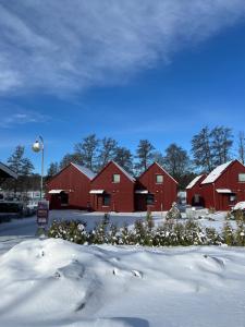 a group of red barns in the snow at Rocklunda Village in Västerås