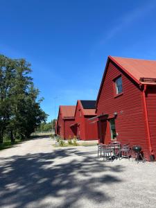 a red barn with tables and chairs in front of it at Rocklunda Village in Västerås