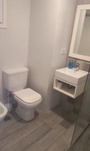 a white bathroom with a toilet and a sink at Ale-MardelPlata-Sicilia in Mar del Plata
