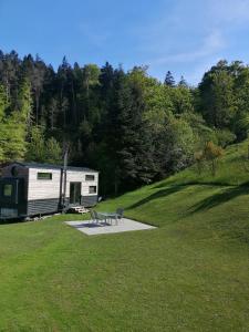 ザンクト・マルグレーテンにあるTiny House im Grünenの野原のピクニックテーブル付きトレーラー