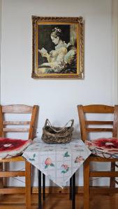 a table and two chairs with a picture on the wall at Triantafillia - Mountain Lodge by Ladonia Εpi in Likouría