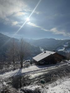 een gebouw op een heuvel met sneeuw op de grond bij Chalet Cosy Les Gets Vue Montagne in Les Gets