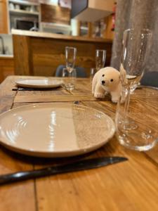 een tafel met borden en glazen en een knuffeldier erop bij Chalet Cosy Les Gets Vue Montagne in Les Gets +16 foto's