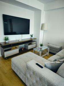 a living room with a couch and a flat screen tv at Depa Bonito en Condominio ! in Tacna