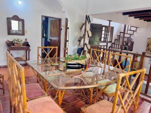 a dining room with a glass table and chairs at Hermosa habitación El Galapo - Zapatoca in Bucaramanga