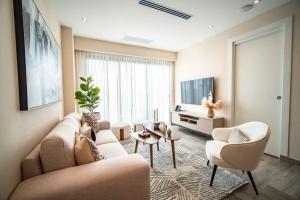 a living room with a couch and chairs and a tv at Aston Rubi City Suites in Santo Domingo