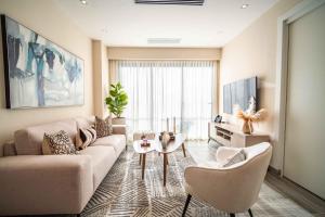 a living room with a couch and chairs and a tv at Aston Rubi City Suites in Santo Domingo