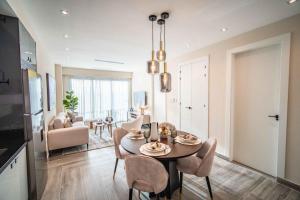 a dining room and living room with a table and chairs at Aston Rubi City Suites in Santo Domingo