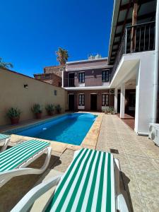 a swimming pool with two lounge chairs next to a building at Hotel Plaza Cafayate in Cafayate +26 photos