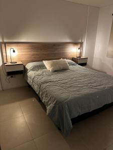 a bedroom with a large bed with two night stands at Departamento Premium Aqua II in Villa Carlos Paz