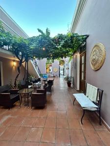 a patio with tables and chairs and trees in a building at Hotel Plaza Cafayate in Cafayate