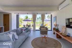 ein Wohnzimmer mit Sofa und Tisch in der Unterkunft Casa com Piscina na Praia de Tatuamunha by Qavi in Tatuamunha