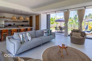 ein Wohnzimmer mit Couch und Küche in der Unterkunft Casa com Piscina na Praia de Tatuamunha by Qavi in Tatuamunha