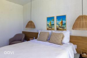 ein Schlafzimmer mit einem Bett und zwei Gemälden an der Wand in der Unterkunft Casa com Piscina na Praia de Tatuamunha by Qavi in Tatuamunha + 28 Fotos