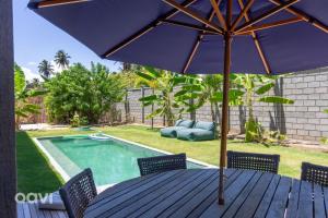 ein Tisch mit Sonnenschirm neben einem Swimmingpool in der Unterkunft Casa com Piscina na Praia de Tatuamunha by Qavi in Tatuamunha