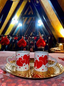 two mugs with hearts on them sitting on a plate at Vila Edi Tuzla in Tuzla +106 photos