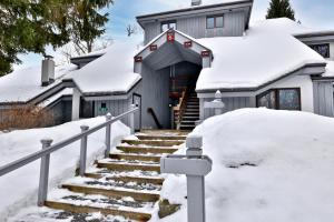 a house with snow on the stairs at Woods Resort and Spa - Cozy 2-Bedroom Condo Minutes to Ski Resort - Spa, Pool, Hot Tub, Tennis, Fireplace in Killington