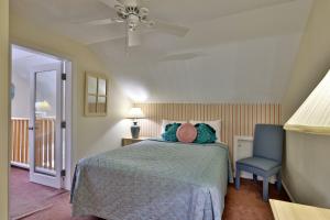 a bedroom with a bed and a blue chair at Woods Resort and Spa - Cozy 2-Bedroom Condo Minutes to Ski Resort - Spa, Pool, Hot Tub, Tennis, Fireplace in Killington +31 photos