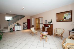 a living room with chairs and a table and stairs at La Janenquelle in Sarry