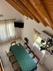 a dining room with a green table and chairs at San rafael del diamante apartamentos in San Rafael