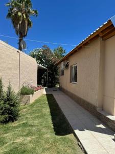 a house with a sidewalk next to a building at San rafael del diamante apartamentos in San Rafael