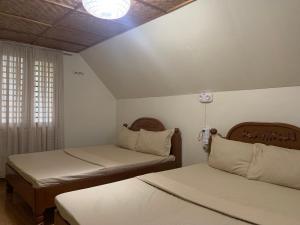 a bedroom with two beds and a window at Valley Breeze Resort in Gabaldon
