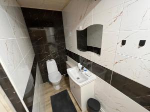 a bathroom with a white toilet and a sink at Juurikkalahti Adventure Center in Kajaani +55 photos