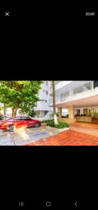 a red car parked in a parking lot next to a building at Marinares apartamento in Cartagena de Indias