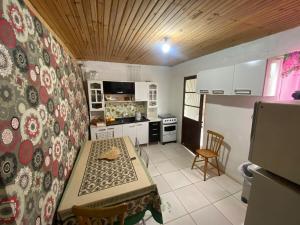 a small kitchen with a table and a stove and a table and chairs at Casa Completa para Hospedagem in Rosário do Sul