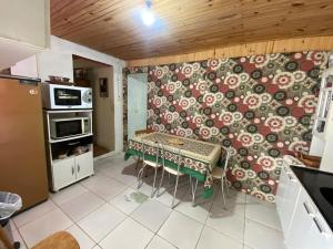 a kitchen with a table and a patterned wall at Casa Completa para Hospedagem in Rosário do Sul +2 photos