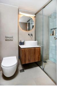 a bathroom with a toilet and a sink and a shower at Agistri House Pefkohori in Pefkochori +16 photos