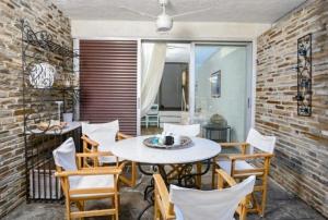 a dining room with a table and chairs at Agistri House Pefkohori in Pefkochori
