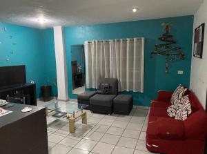 a living room with a red couch and chairs at Departamento con terraza verde in Cholula