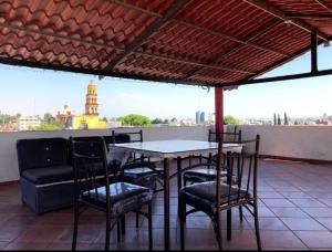 a table and chairs on a patio with a view at Departamento con terraza verde in Cholula