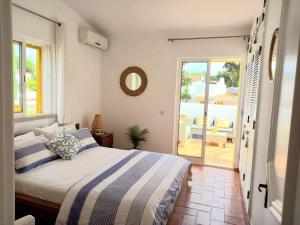 a bedroom with a bed and a view of a patio at Villa Blue - Aldeia do Golfe in Quarteira +28 photos